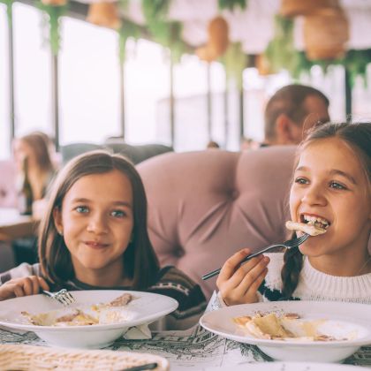 Kinder beim Mittagessen im Familiencafé der Spielstadt.